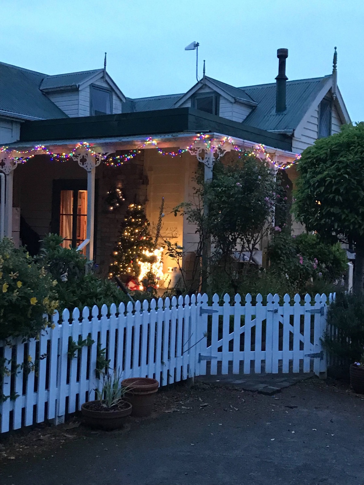 The villa at dusk behind its white picket fence
